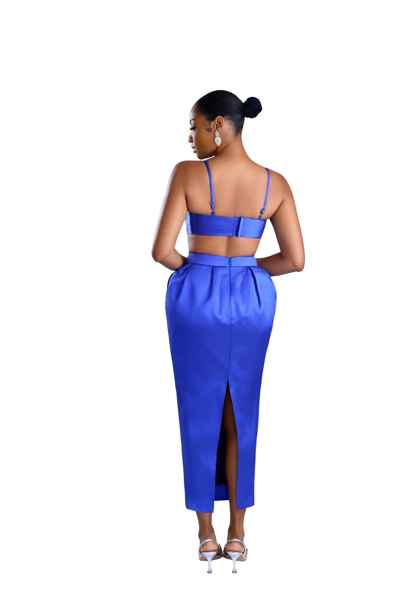 Woman wearing a blue outfit with a high slit on a light background