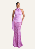 Woman wearing a pink halter neck dress with lace detailing on a light gray background