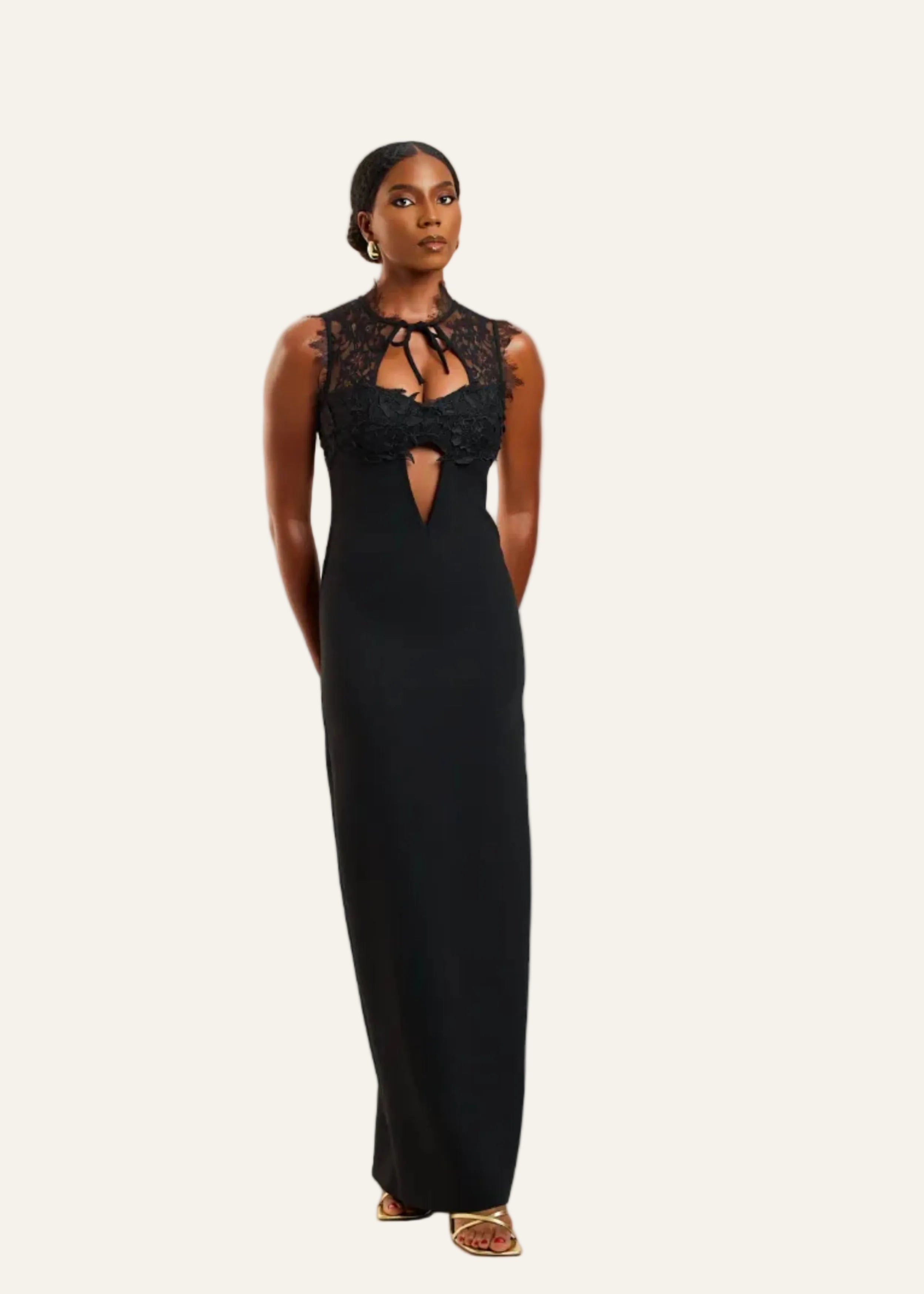 Woman wearing a black evening gown with lace details on a white background