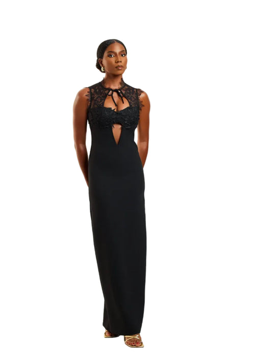 Woman wearing a black evening gown with lace details on a white background