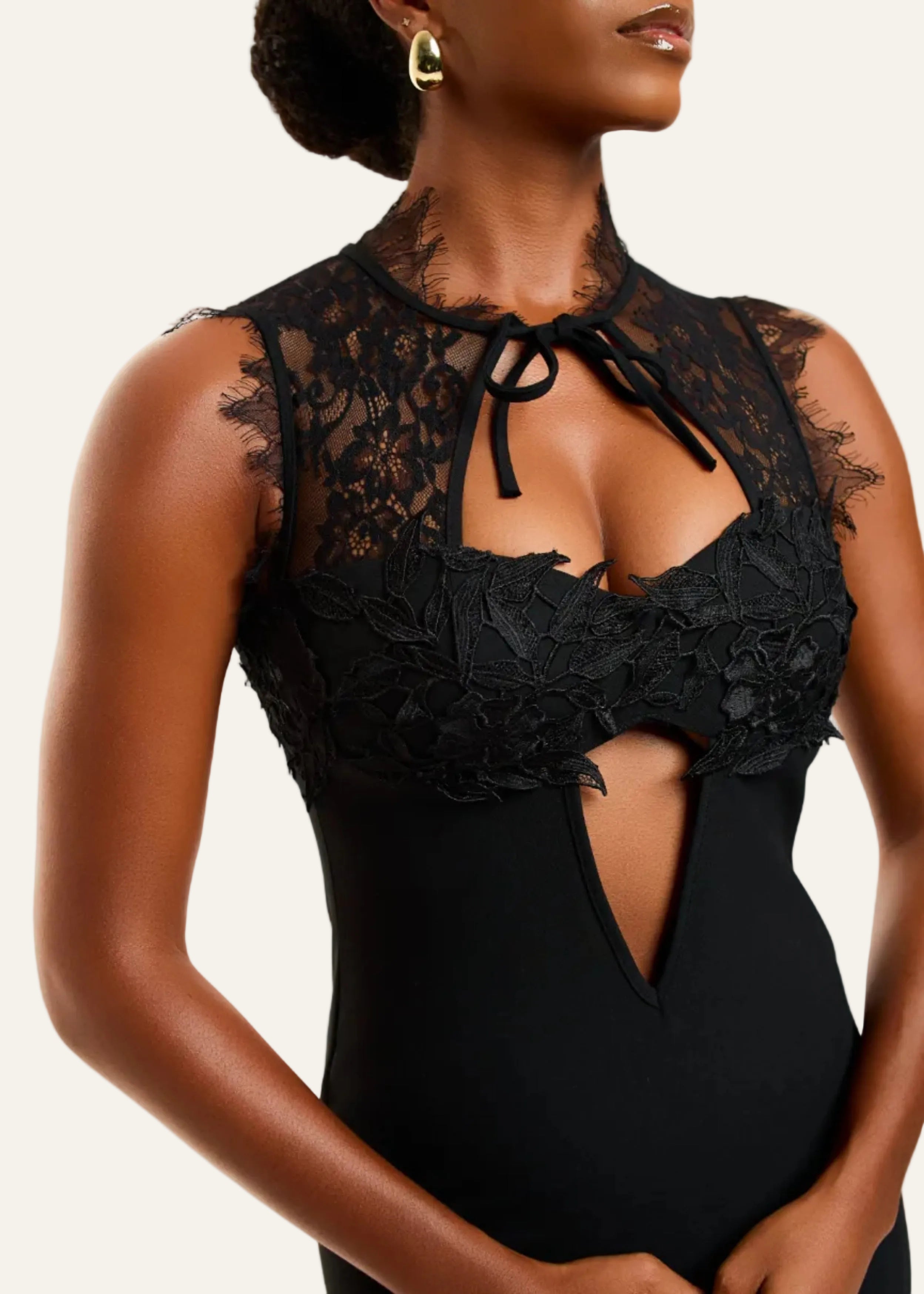 Black lace bodysuit worn by a model on a white background