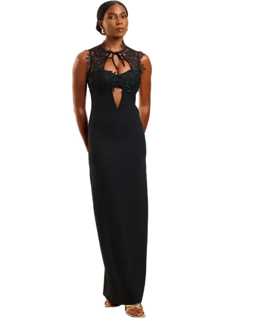 Woman wearing a black evening gown with lace details on a white background