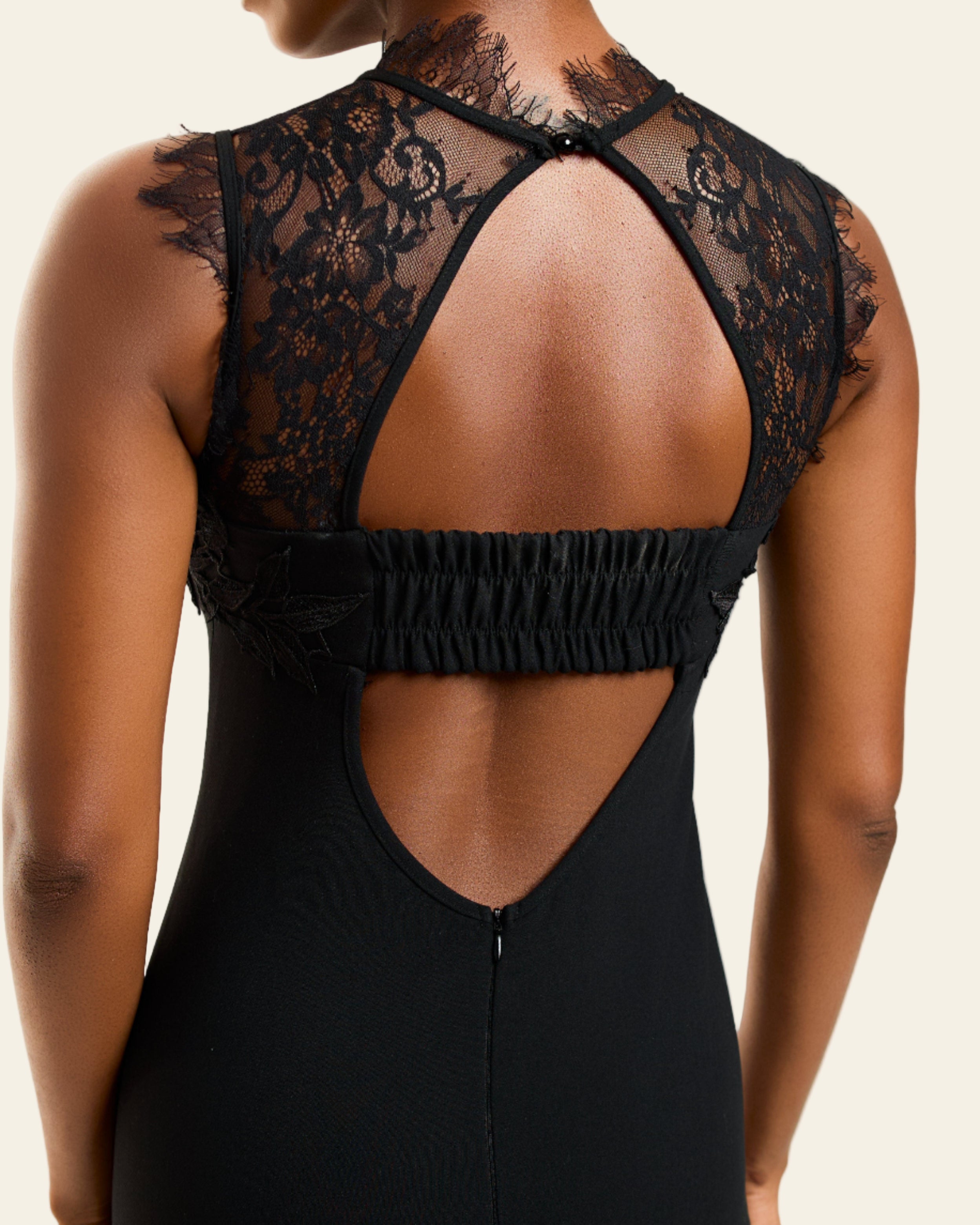 Black lace dress with open back on a model against a white background